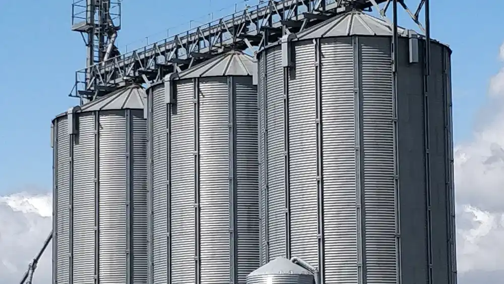 Silos metálicos de armazenagem de grãos contra o céu.